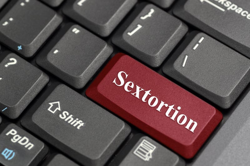 Stock photo of keyboard with red "sextortion button"