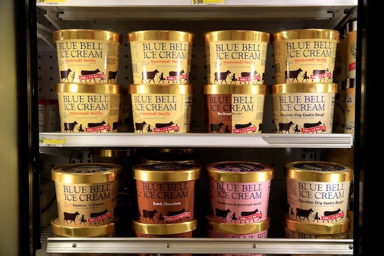 Cartons of Blue Bell ice cream in a grocery store freezer