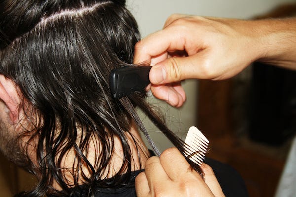 Man with long hair getting haircut