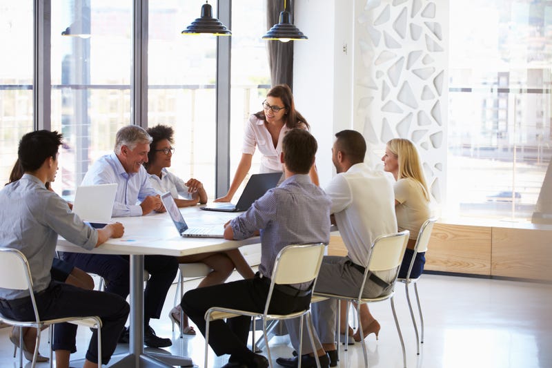 coworkers sitting around office table 