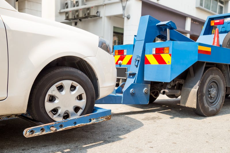 tow truck towing a broken down car