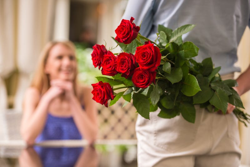 Man giving woman flowers stock photo. 