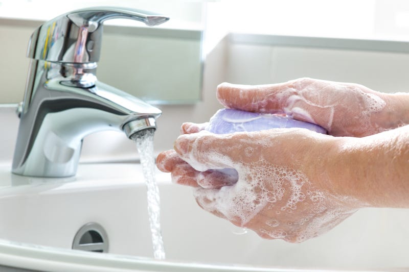 Person washing their hands with a bar of soap.