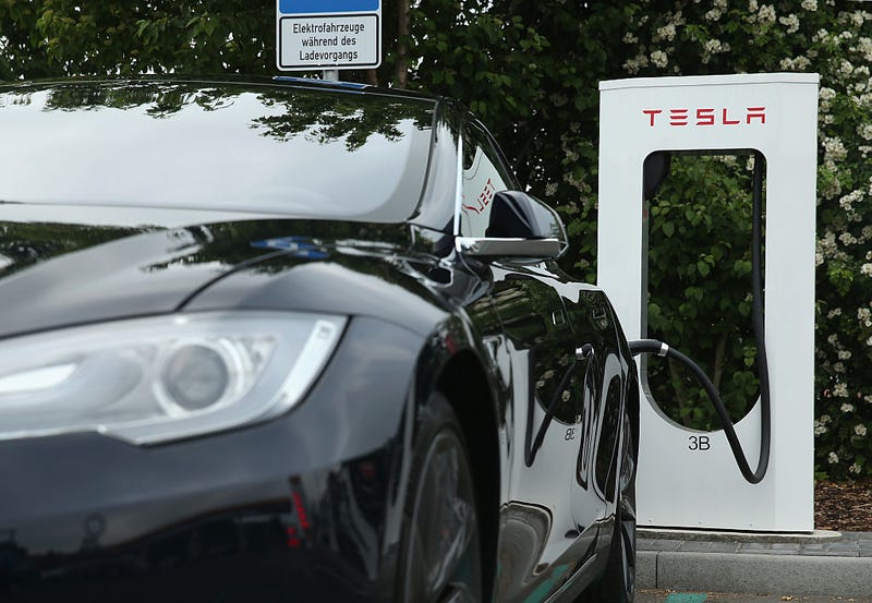 A Tesla electric-powered sedan stands at a Tesla charging staiton at a highway reststop along the A7 highway on June 11, 2015 near Rieden, Germany. 