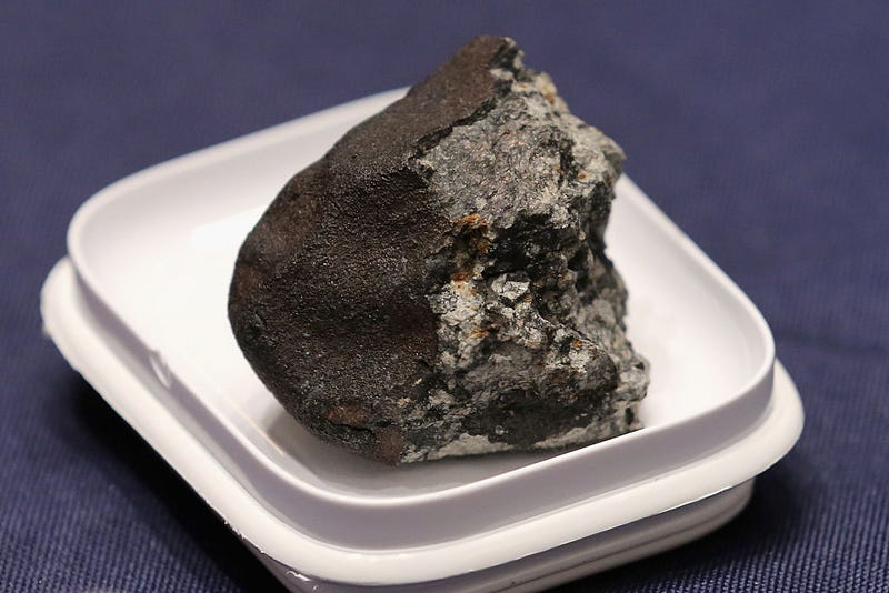 A piece of the Chelyabinsk meteorite is displayed before a hearing of the House Administration Committee in the Longworth House Office Building on Capitol Hill June 17, 2015 in Washington, DC. Famously caught by a number of video cameras, the meteorite fell to earth February 15, 2013 and caused a large amount of damage in the city of Chelyabinsk, Russia. (Photo by Chip Somodevilla/Getty Images)