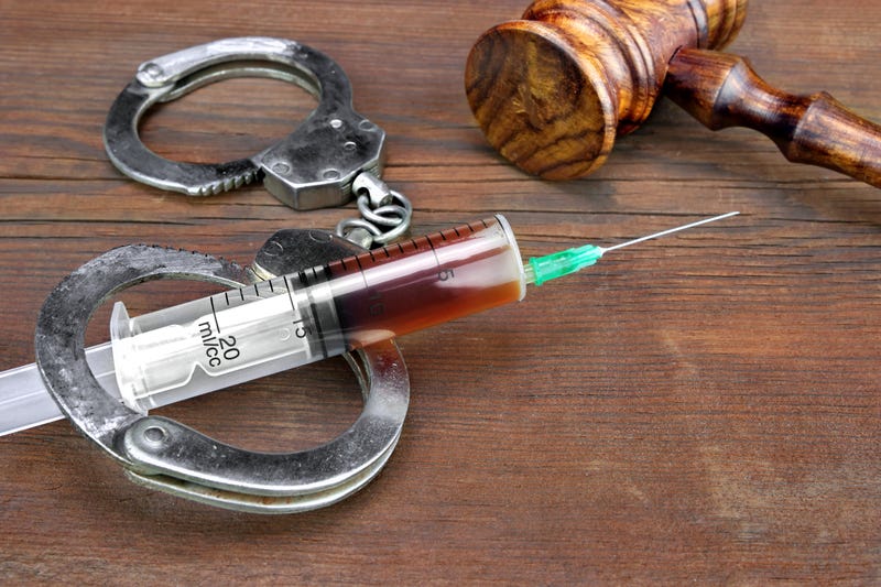 Close-up Of Judges Gavel And Syringe With Injection On The Brown Wood Rough Background