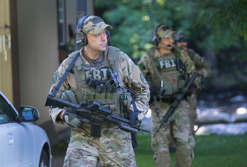 FBI agents with guns drawn