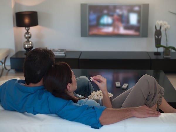 Couple watching TV and eating popcorn
