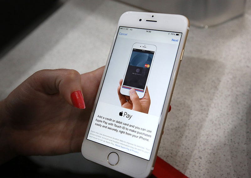 In this photo illustration, an iPhone is used to make an Apple Pay purchase at The Post Office on July 14, 2015 in London, England.