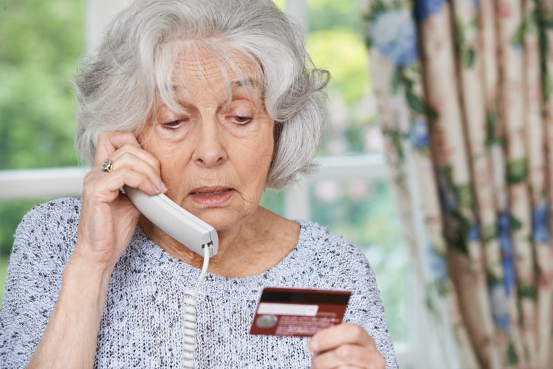 An elderly woman gives her credit card information over the phone