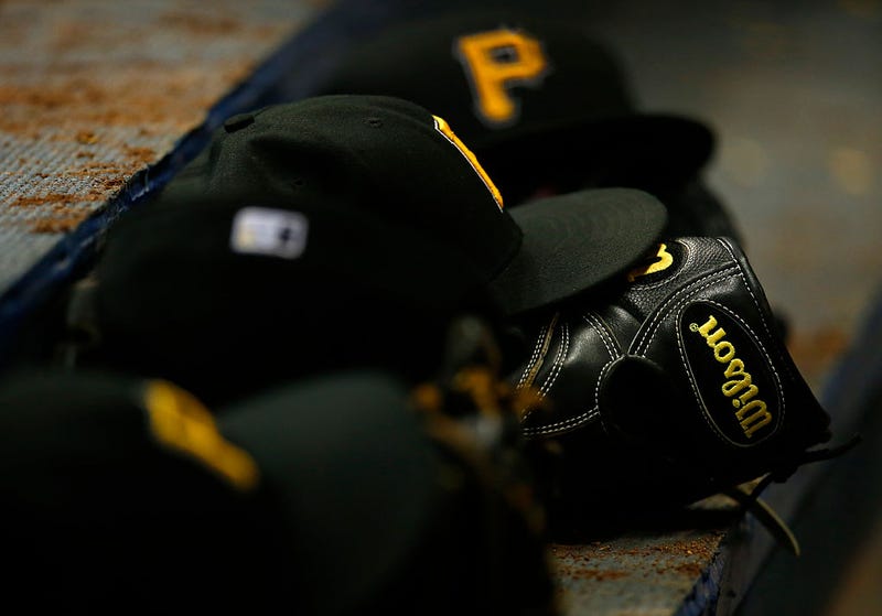 A Wilson glove and hats sit in the Pittsburgh Pirates dugout 
