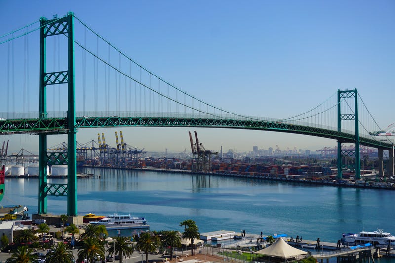 green suspension bridge crossing harbor