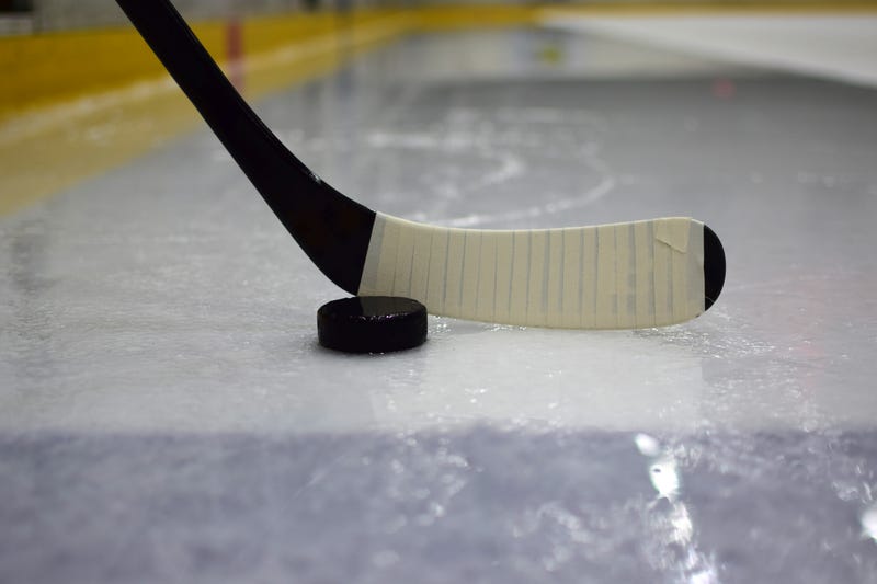 Hockey stick and puck on an ice rink