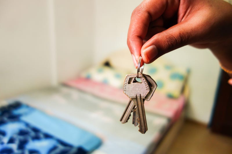 Keys in front of a bed, background blurred. 