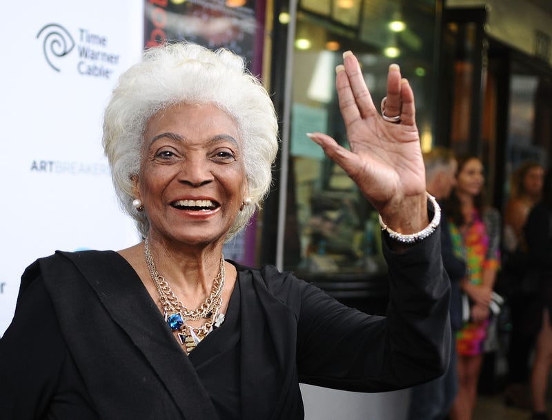 Nichelle Nichols waving at the camera, smiling