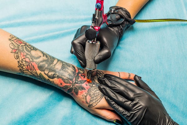 Woman getting a tattoo on her hand