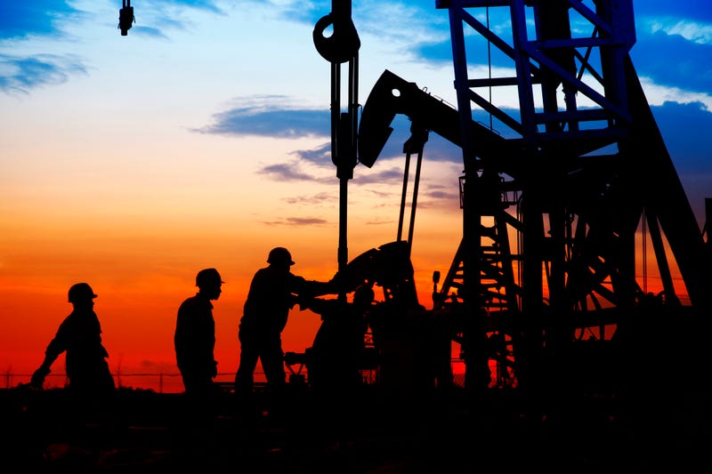 Roughneck (out of focus) looking at a huge oil rig being constructed