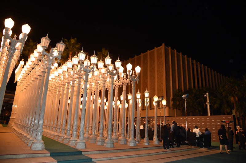 dozens of white painted streetlights lined up in a plaza