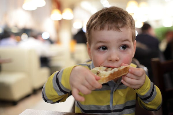 Boy eating bruschetta at a restaurant