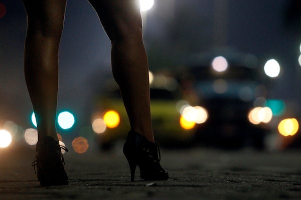 Woman at night wearing heels staring at cars