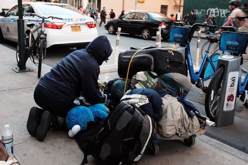 A homeless woman panhandles on the street in New York City.