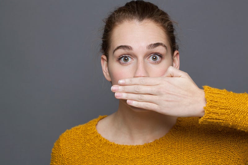 Woman with hand over her mouth