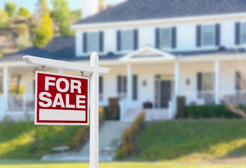House with for sale sign in front
