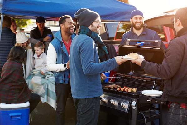 Group of sports fan tailgating in stadium parking lot