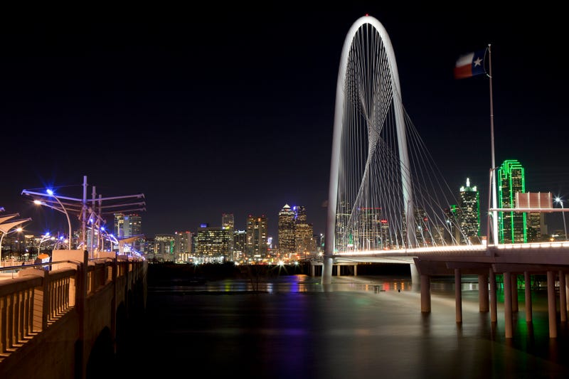Dallas, Texas at night with the Trinity River in the foreground and the Margaret Hunt Hill Bridge