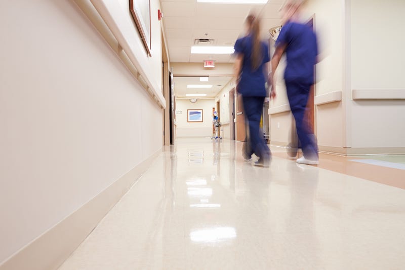 Two nurses walking down hospital corridor