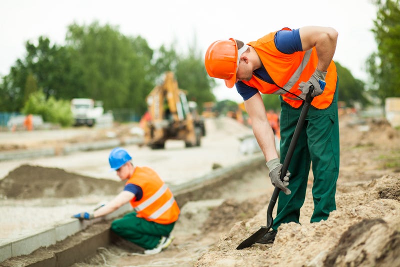 Men wearing orange work vests in construction zone