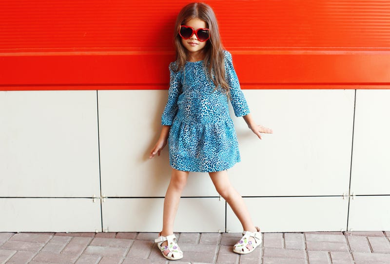 little girl wearing a leopard dress and sunglass 