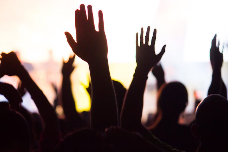 Church congregation with arms raised