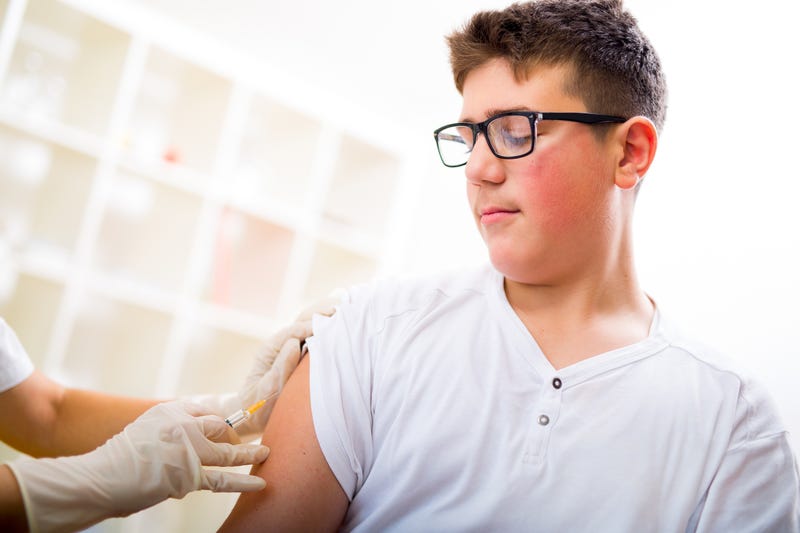 A teenage boy gets T-DAP vaccine for whooping cough.