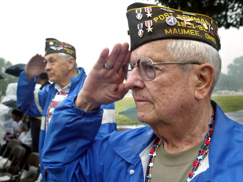 World War II veterans (L-R) Robert Zeller and Larry Monroe salute the American flag as it passes by in the Memorial Day Parade