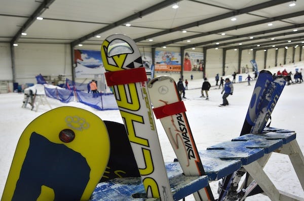 Skis and snowboards inside an indoor facility