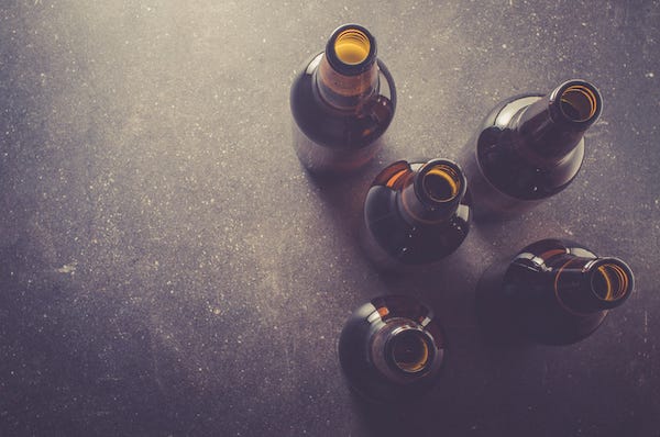 Beer bottles resting on a dark table
