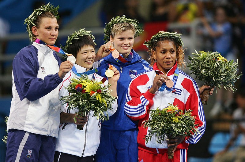 The medal winners (L-R) Claudia Heill (silever) of Austria, Ayumi Tanimoto (Gold) of Japan, Urska Zolnir (Bronze) of Slovenia and Driulys Gonzalez (Bronze) of Cuba pose for photographers after the women's judo -63 kg class event on August 17, 2004 during the Athens 2004 Summer Olympic Games