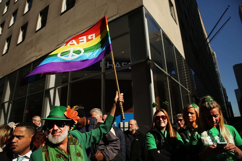 A man holds up a Pride flag at the annual St. Patrick's Day parade in Manhattan, where LGBTQ groups are allowed to march in the parade