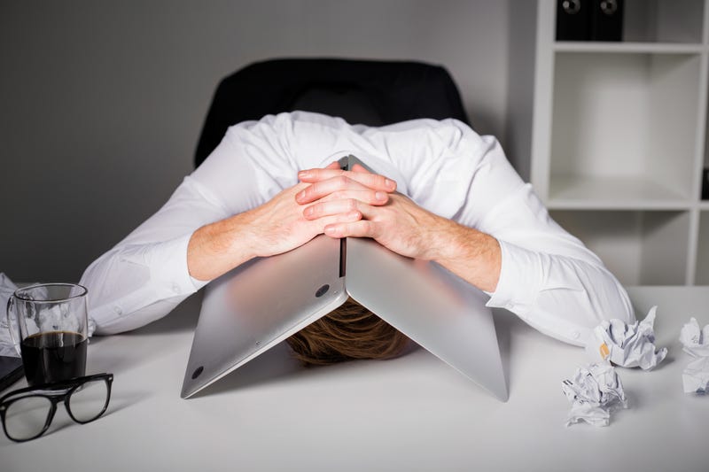 Man hiding under laptop.