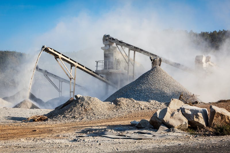 Industrial background - crusher rock stone crushing machine at open pit mining and processing plant for crushed stone, sand and gravel.