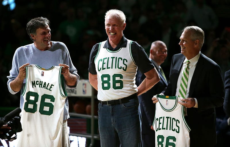 Kevin McHale (left) holds up an honorary jersey with former teammates.