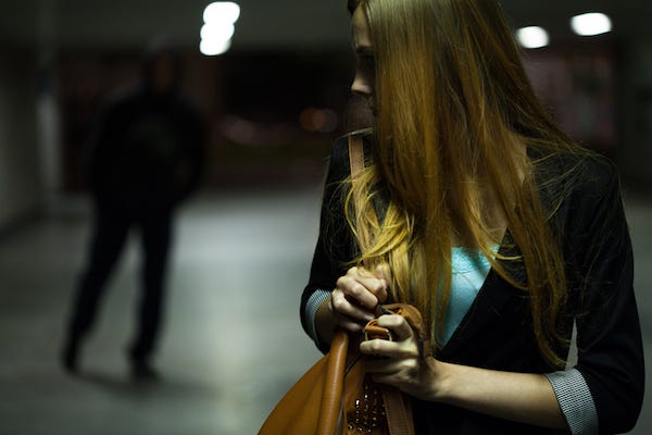 Man stalking woman in a parking garage