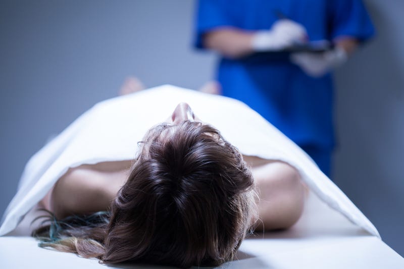 Closeup of remains of woman lying in morgue