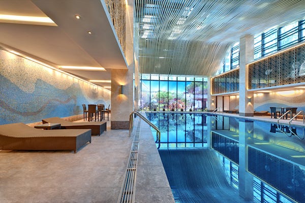 Indoor swimming pool with sun lounger on a bright day