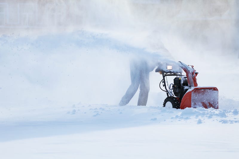 Man operating snow blower