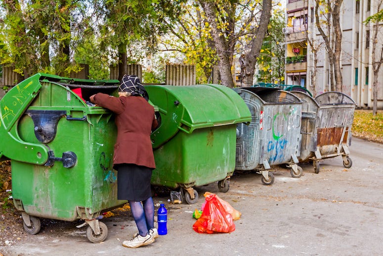 Woman looking through dumpster