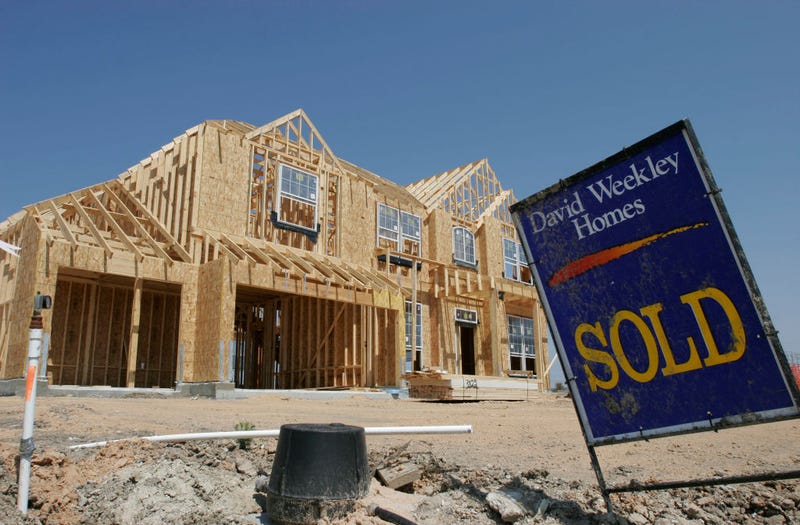 A sold sign sits near a home site in a Texas subdivision.