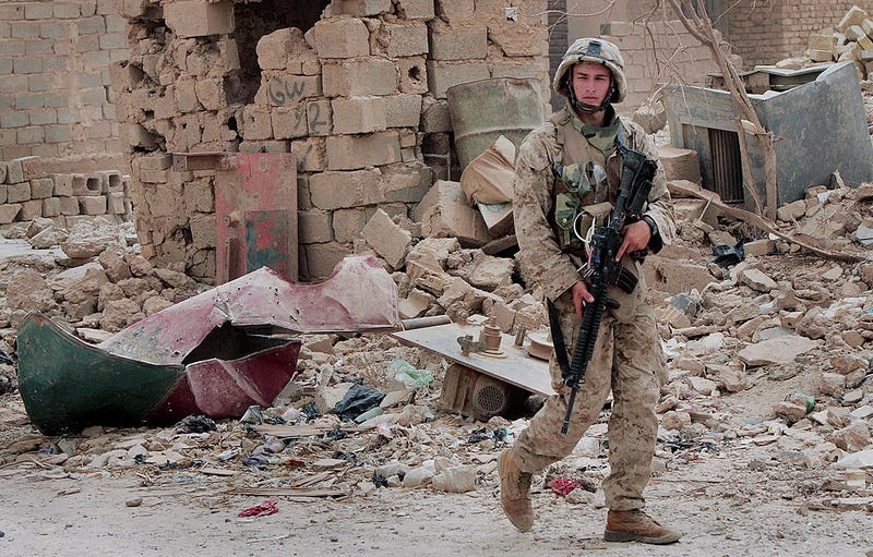 FALLUJAH, IRAQ - AUGUST 11: U.S. Marine Pfc. Anthony Cafferelli from Echo Company 2nd Battalion 7th Marines patrols August 11, 2005 in Fallujah, Iraq. Much of the city is rubble after a prolonged period fighting to remove insurgents. (Photo by Scott Olson/Getty Images)