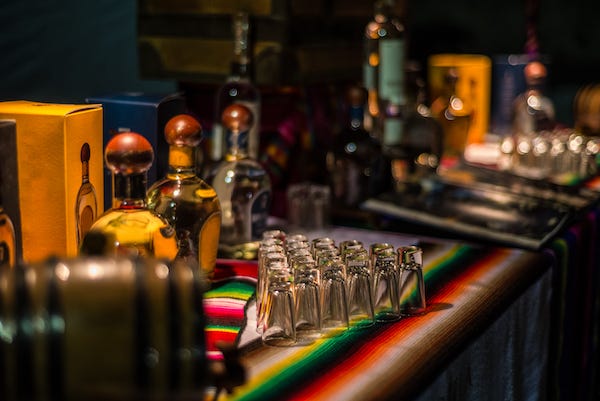 Tequila, Mezcal, and glasses resting on a bar